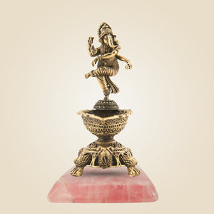 Decorative statue of a deity on a pink stone base with a beige background
