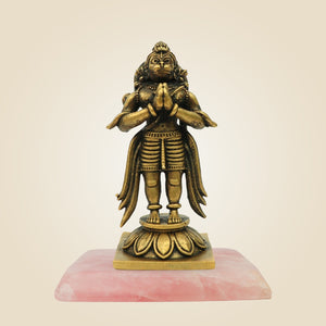 Bronze statue on a pink base against a beige background