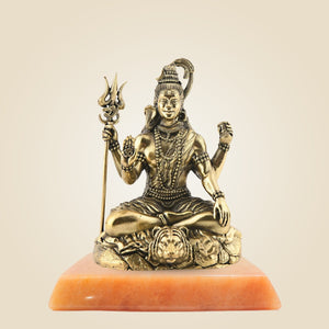 Bronze statue of a seated figure with a trident on an orange pedestal against a beige background