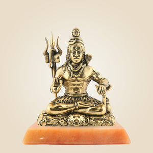 Bronze statue of a seated figure with a trident on a beige background