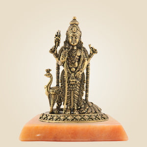Bronze statue of a deity on an orange pedestal against a beige background