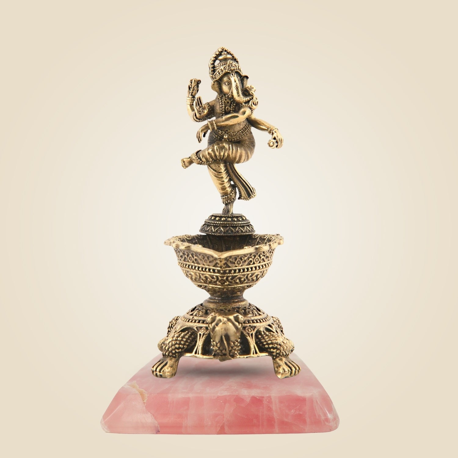 Decorative statue of a deity on a pink stone base with a beige background