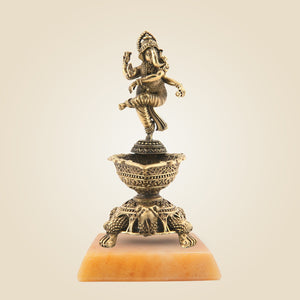 Bronze statue of a deity on a pedestal with a beige background