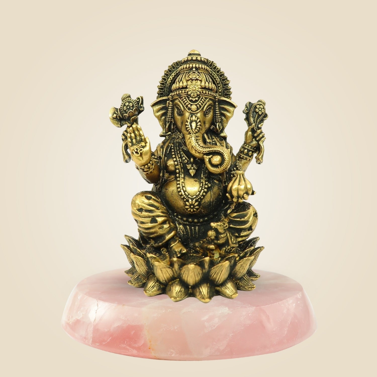 Decorative statue of a deity on a pink stone base against a beige background