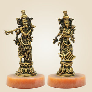 Two ornate statues on red bases against a beige background