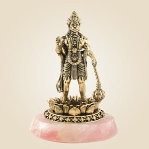 Bronze statue of a deity on a pink stone base against a beige background