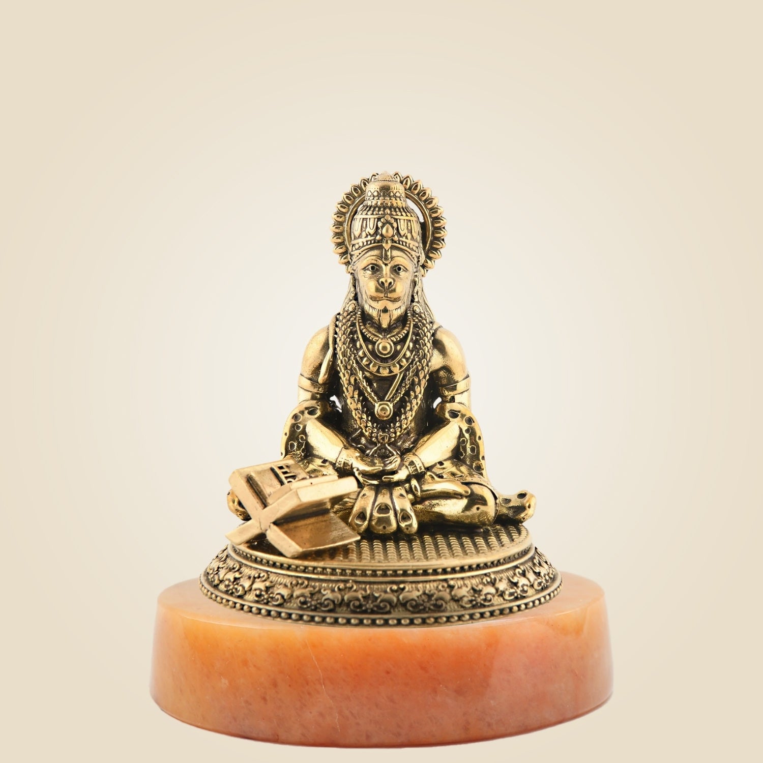 Gold-colored statue on a red base against a beige background