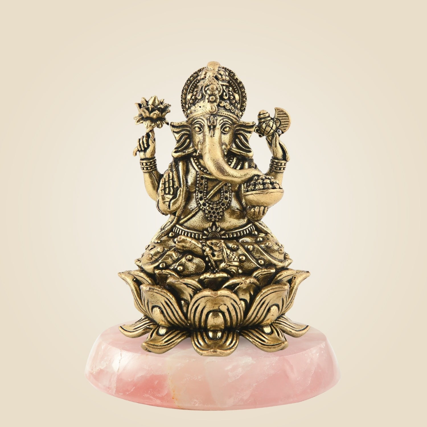 Bronze statue of a deity on a pink stone base against a beige background