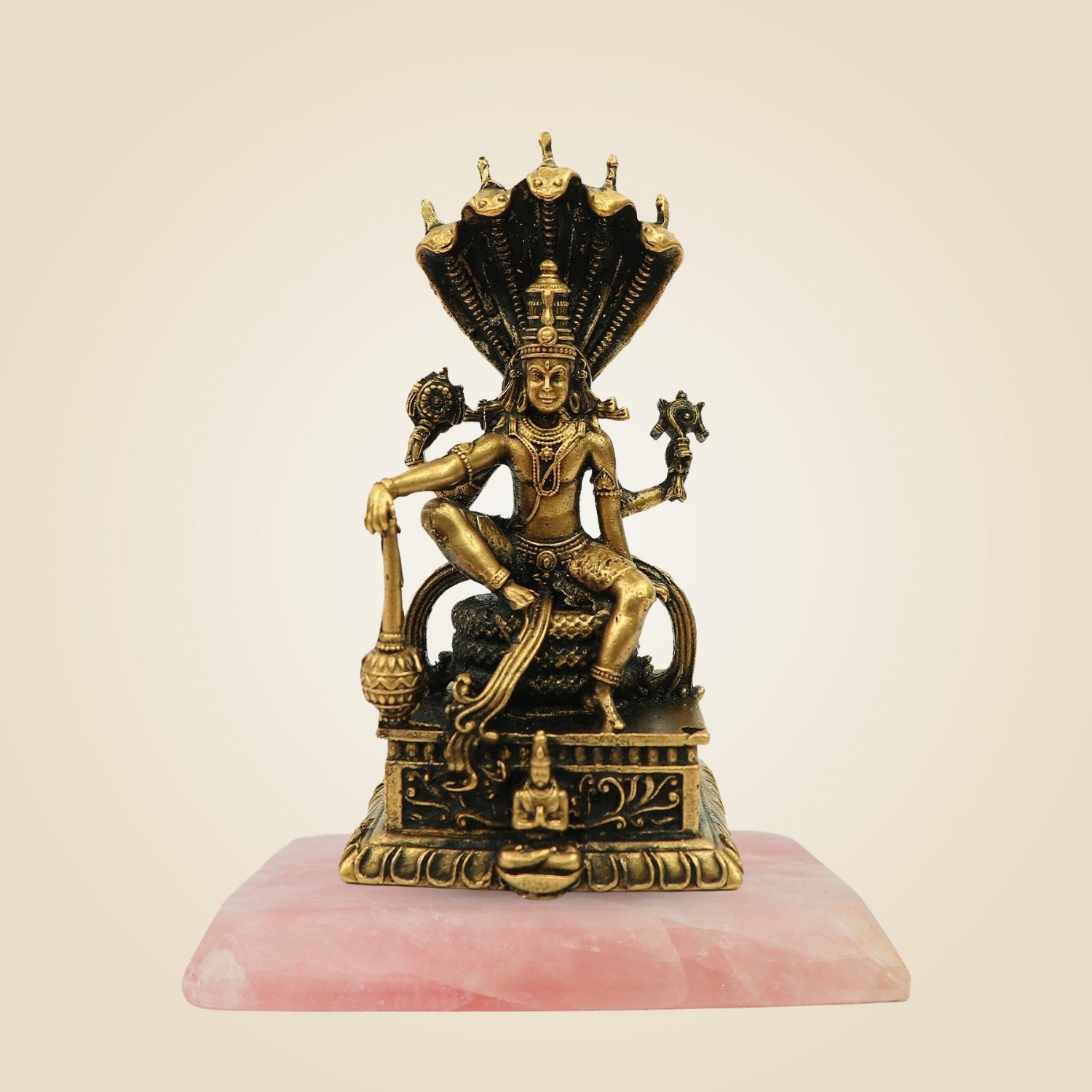 Decorative statue on a pink base with a beige background