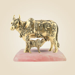 Decorative brass sculpture of a bull with engravings on a pink base