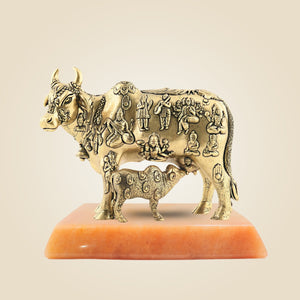 Bronze sculpture of a bull with carvings on a beige background