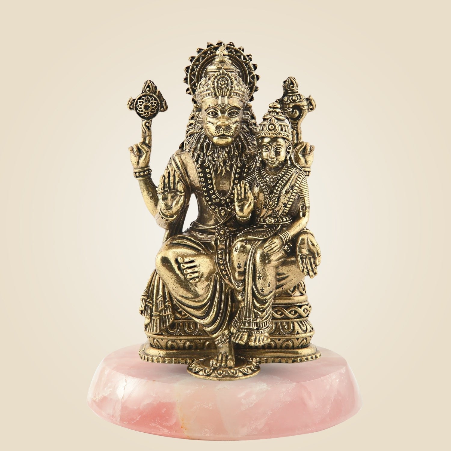 Bronze statue of a seated figure with a child on a pink stone base against a beige background